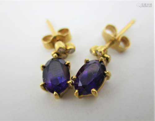 A pair of 18ct gold earrings, each set with three diamonds and an amethyst pendant, 2.3g in a