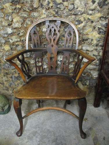 A late 19th/early 20th century Gothic style ash and elm low back Windsor armchair, with pierced back