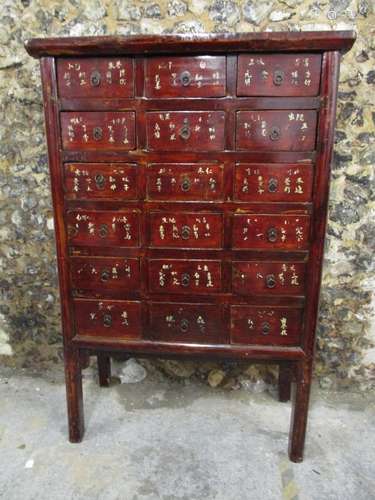 A 20th century Chinese apothecary chest on legs, comprising eight drawers with hoop handles and