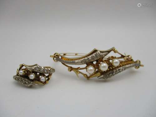 A gold coloured metal bracelet set with three pearls, flanked by stylized flowers and white metal