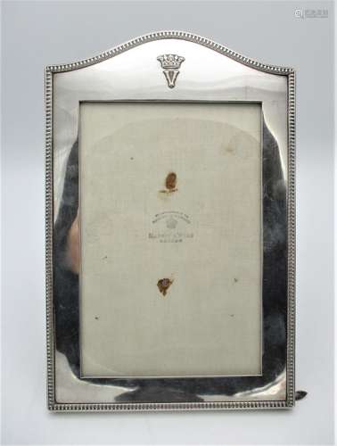 A George V silver photograph frame by Mappin & Webb, London 1923, with arched top, patterned