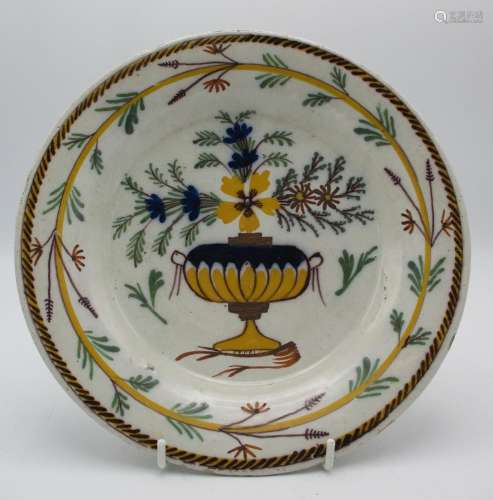 An 18th century continental Delft tin glazed plate, possibly Dutch, designed with polychrome flowers