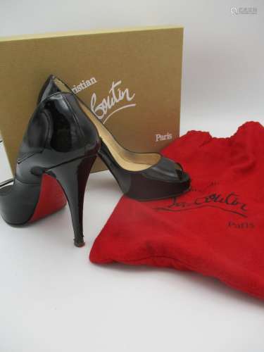 A pair of boxed Christian Louboutin black patent leather open toe stiletto with iconic red