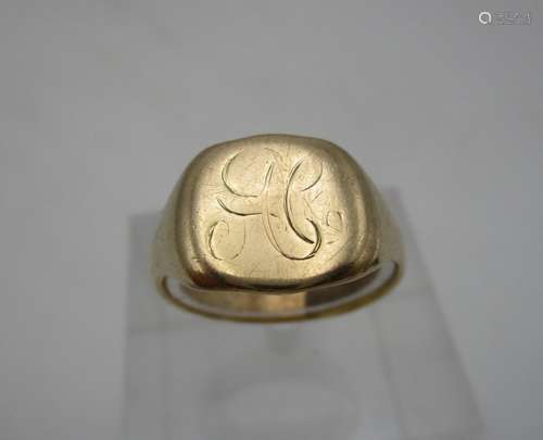 A gold coloured metal signet ring with worn initials, 6.2g, size R