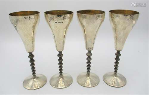 A set of four Elizabeth II silver wine goblets by Stuart Devlin, London 1979, with hammered