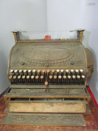 A National Cash Register Co brass till with wreath and scrolled foliage ornament, a hinged front,