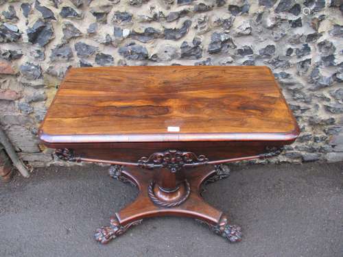 A William IV rosewood card table with a rotating foldover top, over an octagonal vase shaped