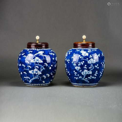 A PAIR OF BLUE AND WHITE 'PRUNUS' JARS AND WOODEN COVERS