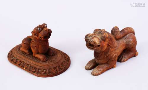 TWO 19TH CENTURY INDIAN MAYSORE CARVED SANDALWOOD FIGURES OF RECUMBENT LIONS, one on a rectangular