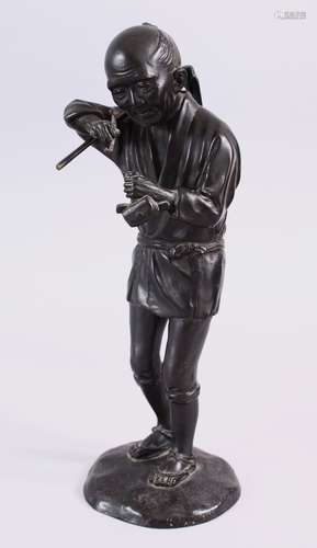 A JAPANESE MEIJI PERIOD BRONZE OKIMONO - SMOKING MAN, the figure stood upon stylized base, holding