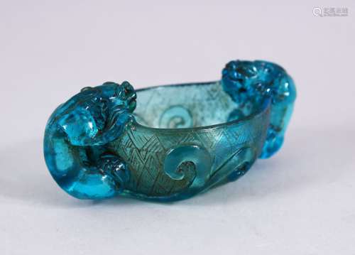 A CHINESE BLUE PEKING GLASS LIBATION CUP, with twin chilong handles, amongst lotus, 10cm.