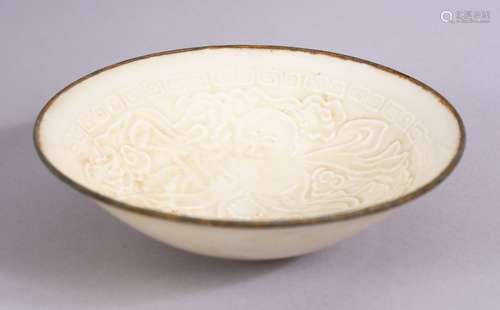 A RARE SONG STYLE CARVED CHINESE DING YAO PORCELAIN BOWL, carved with a boy amongst clouds, With