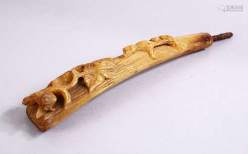 A 19TH CENTURY CARVED RHINOCEROS HORN STICK HANDLE, carved with a four legged animal amongst