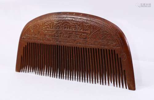 A 19TH CENTURY PERSIAN WOOD COMB CARVED WITH CALLIGRAPHY, 17cm wide.