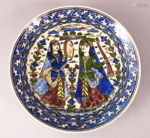 A LARGE 19TH CENTURY PERSIAN QAJAR GLAZED POTTERY CHARGER, with two figures in landscapes, 33cm