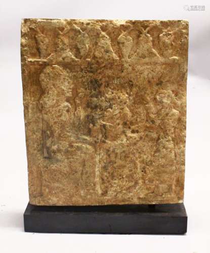 A LARGE ANCIENT NORTH EASTERN CARVED STONE PANEL, depicting figures, one seated interior, 49cm