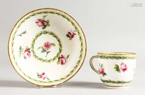 A SEVRES COFFEE CUP AND SAUCER painted with roses between husk borders, gilder's mark for