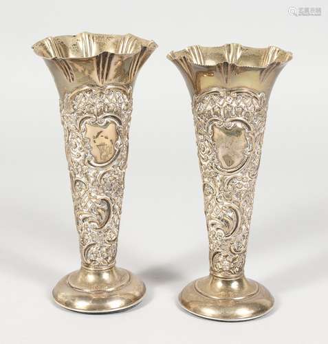 A PAIR OF TAPERING REPOUSSE SPILL VASES, with plain loaded circular bases. 6ins high. Chester 1899.