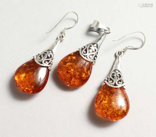 A SILVER AND AMBER PENDANT with a pair of matching earrings.