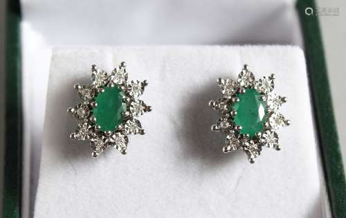 A GOLD PAIR OF 9CT GOLD, DIAMOND AND EMERALD DAISY CLUSTER EARRINGS.