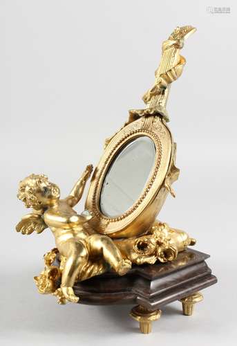 A GILT BRONZE TABLE MIRROR modelled as a cherub holding a lute. 12ins high.