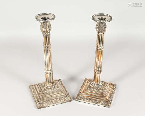 A PAIR OF ADAM DESIGN PLATE CANDLESTICKS with fluted stems, on shaped bases. 12ins high.