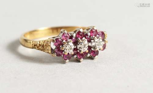 AN 18CT GOLD RUBY AND DIAMOND TRIPLE FLOWER HEAD RING.