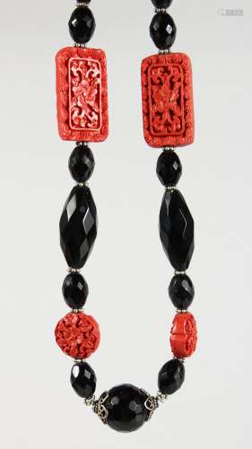 A CINNABAR LACQUER AND JET BEAD NECKLACE. 26ins long.