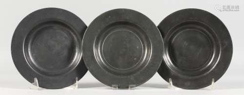 THREE EARLY PEWTER CIRCULAR PLATES, stamped LONDON. 7ins diameter.