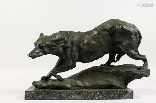 AN ABSTRACT BRONZE OF A PROWLING WOLF, on a marble base. 17ins long.