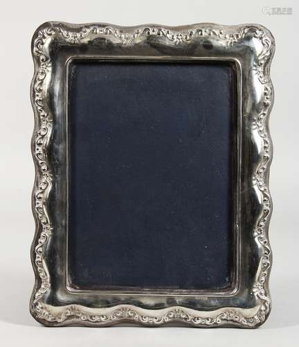 A SILVER PHOTOGRAPH FRAME with shaped edge. 11ins x 8ins.