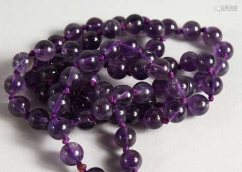 AN AMETHYST BEAD NECKLACE. 27ins long.