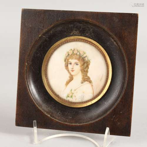 A CIRCULAR PORTRAIT MINIATURE OF A YOUNG LADY in a wooden frame. 2.25ins. Signed.