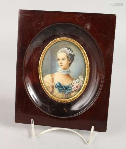 AN OVAL PORTRAIT MINIATURE OF A YOUNG LADY in a wooden frame. 3.25ins x 2.5ins. Signed.