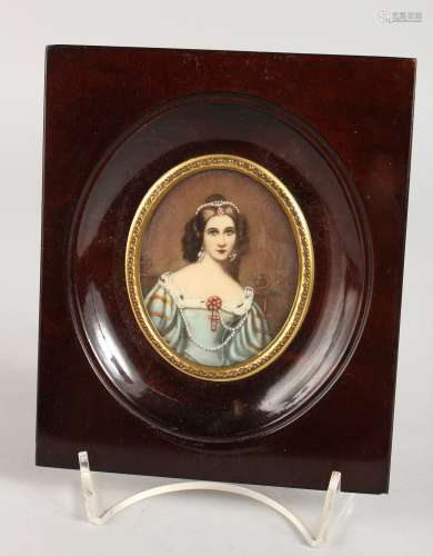 AN OVAL PORTRAIT MINIATURE OF A YOUNG LADY in a wooden frame. 2.5ins x 2ins. Signed.