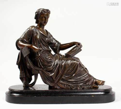 A CLASSICAL BRONZE OF A SEATED YOUNG LADY, reading a book, on a wooden base. 10ins long.