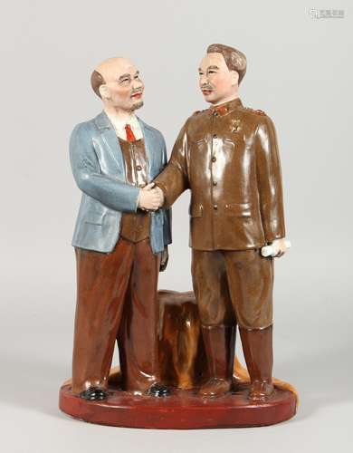 A RUSSIAN POTTERY GROUP, two figures standing shaking hands. 13.5ins high.