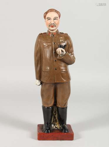 A RUSSIAN POTTERY STANDING FIGURE, holding a pipe. 13ins high.