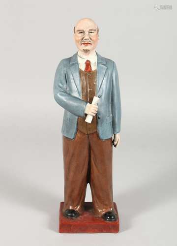 A RUSSIAN POTTERY STANDING FIGURE, holding a paper. 13ins high.