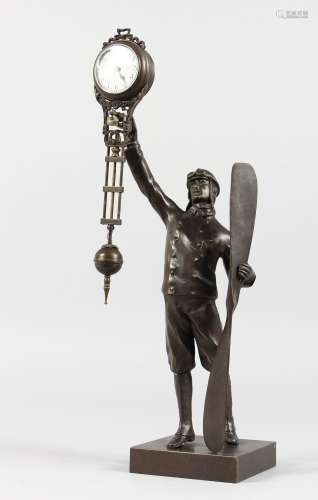 A BRONZE REPRODUCTION MYSTERY CLOCK, modelled as an early aviator. 15ins high.