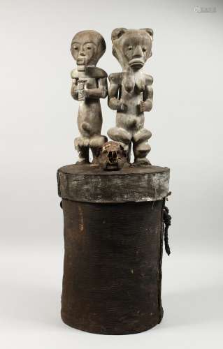 A LARGE EARLY NATIVE CIRCULAR BOX, the cover carved with two figures and a skull. 32ins high.