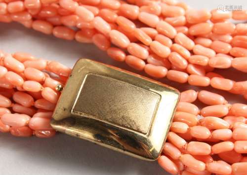 A TWELVE STRAND CORAL AND BEAD NECKLACE with 14ct gold clasp. 20ins long.