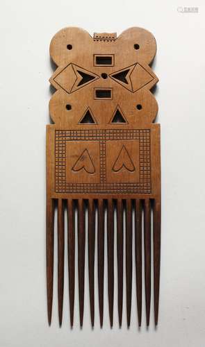 A TRIBAL CARVED WOOD COMB.