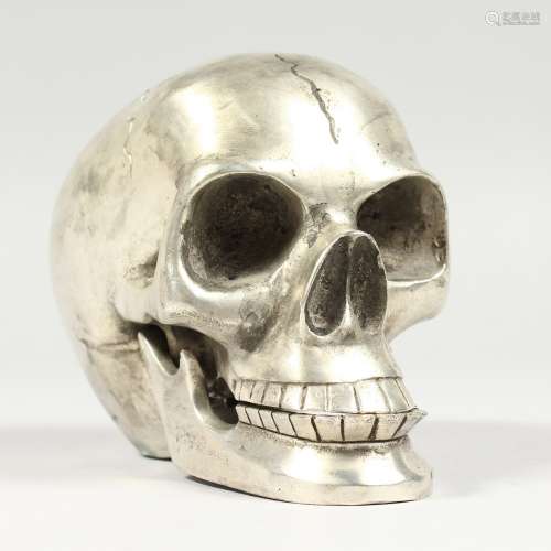 A PLATED MODEL OF A HUMAN SKULL. 5ins long.