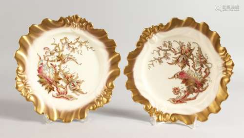 A ROYAL WORCESTER PAIR OF PLATES of silver shape, each decorated with enamels and raised gilding
