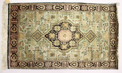 A SMALL PERSIAN SILK RUG, 20TH CENTURY, with a central star shape motif and decorated with