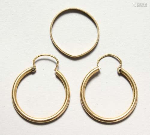 A PAIR OF GOLD HOOP EARRINGS and a large ring.