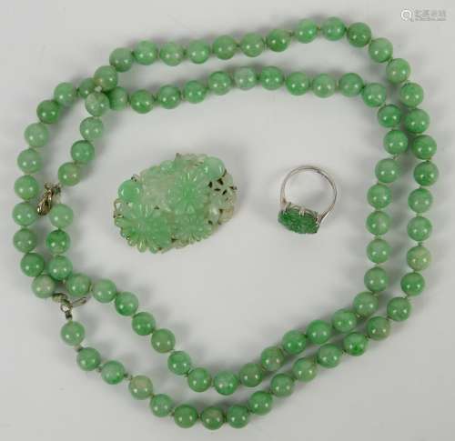 A mottled jadeite or jadeite style necklace mounted with about 85 spherical beads; together with a