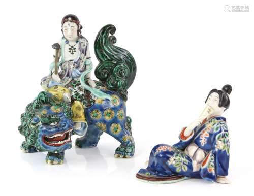 A Japanese porcelain figure of a Buddhist Deity, seated on the back of a karashishi, 21 cm high;