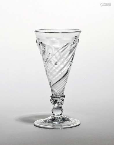 A dwarf ale glass c.1740, the drawn trumpet bowl with spiral moulding rising to a flammiform edge,